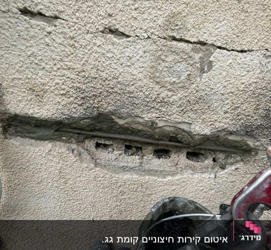 קיר עם סדקים, חורים וציוד טיפוס מתכת